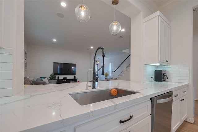 14439 Basalt Ln, Houston, TX 77077 - kitchen with stainless steel dishwasher, open floor plan, light stone countertops, white cabinetry, and recessed lighting