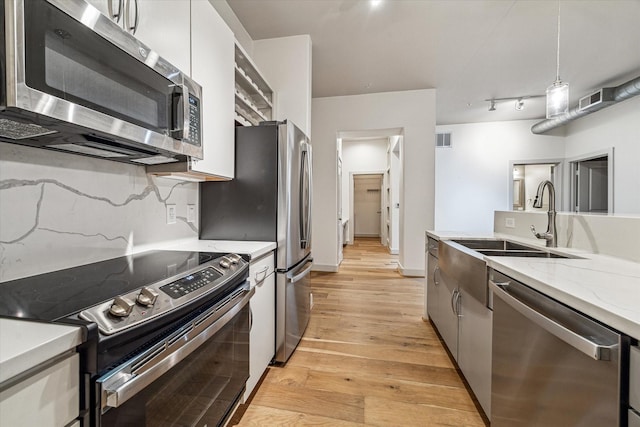 1901 Post Oak Blvd Unit 1206, Houston, TX 77056 - kitchen with appliances with stainless steel finishes, light wood-type flooring, hanging light fixtures, and modern cabinets