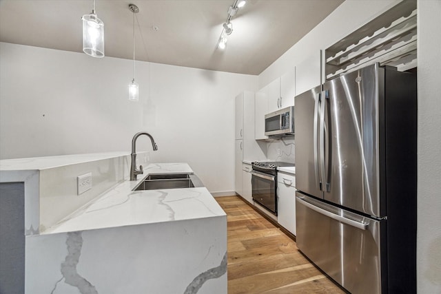 1901 Post Oak Blvd Unit 1206, Houston, TX 77056 - kitchen featuring stainless steel appliances, light wood-style flooring, white cabinets, decorative light fixtures, and light stone counters