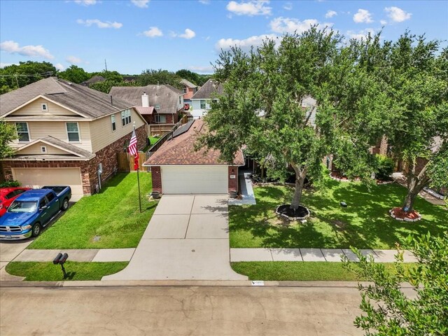 1803 Winding Trail Ln, Alvin, TX 77511 - view of front of home featuring brick siding, a front lawn, driveway, a garage, and a residential view
