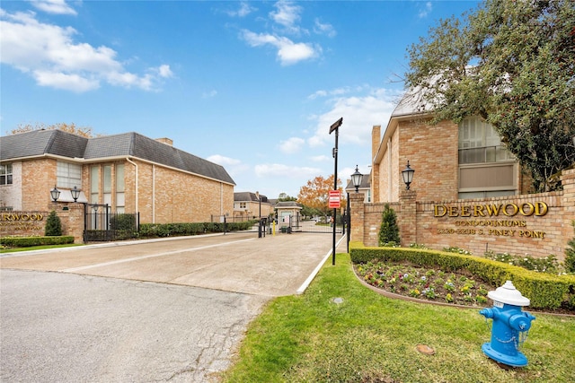 2230 S Piney Point Rd Unit 206, Houston, TX 77063 - view of concrete street with a gate, a gated entry, street lights, and curbs
