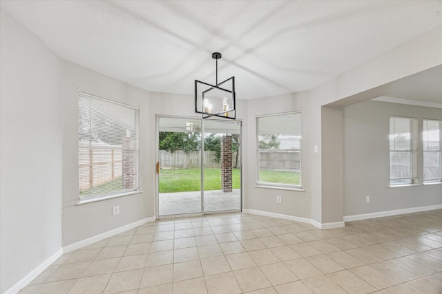 21619 Knightsbrook Ln, Katy, TX 77449 - unfurnished dining area featuring light tile patterned flooring, healthy amount of natural light, a chandelier, and a textured ceiling