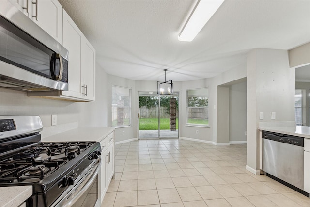 21619 Knightsbrook Ln, Katy, TX 77449 - kitchen with stainless steel appliances, light countertops, light tile patterned floors, and white cabinetry