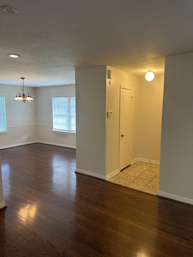 9337 Walterville Rd, Houston, TX 77080 - spare room with a chandelier, a textured ceiling, wood finished floors, and healthy amount of natural light