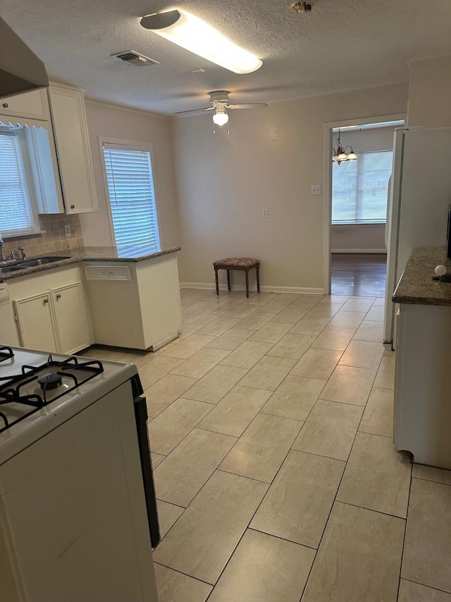 9337 Walterville Rd, Houston, TX 77080 - kitchen featuring gas range, a textured ceiling, light tile patterned flooring, white cabinetry, and backsplash