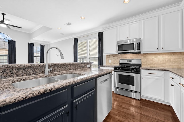 1320 Studer St, Houston, TX 77007 - kitchen with stainless steel appliances, ornamental molding, white cabinetry, stone counters, and decorative backsplash