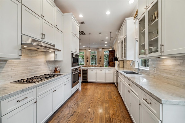 1126 Lake Pointe Pkwy, Sugar Land, TX 77478 - kitchen with wine cooler, stainless steel appliances, under cabinet range hood, white cabinetry, and recessed lighting