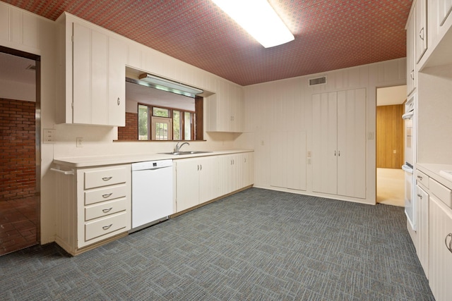 303 S Jackson St, Alvin, TX 77511 - kitchen featuring white appliances, light countertops, dark carpet, and white cabinetry