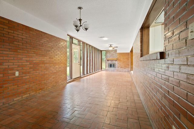 303 S Jackson St, Alvin, TX 77511 - hall featuring brick wall, brick flooring, and a chandelier
