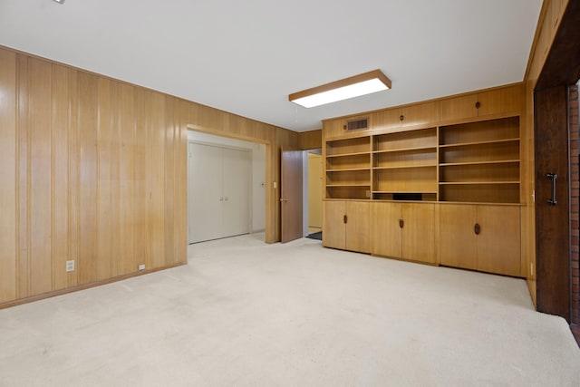 303 S Jackson St, Alvin, TX 77511 - unfurnished living room featuring light colored carpet and wood walls