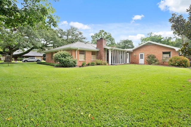303 S Jackson St, Alvin, TX 77511 - back of house with brick siding, a chimney, and a lawn