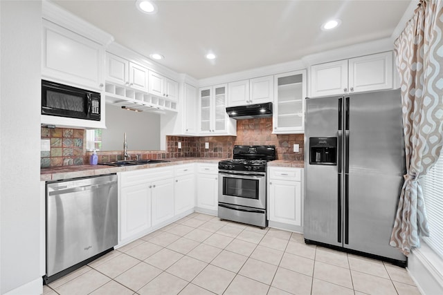 20042 S Pecos Valley Trl, Katy, TX 77449 - kitchen featuring appliances with stainless steel finishes, under cabinet range hood, glass insert cabinets, white cabinetry, and backsplash