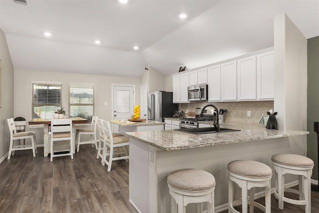 3051 Newcastle Crest Ln, Dickinson, TX 77539 - kitchen featuring stainless steel appliances, lofted ceiling, a kitchen island, dark wood-style flooring, and white cabinetry