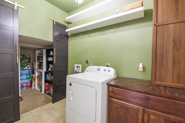 4723 Peninsula Garden Way, Humble, TX 77396 - washroom with washer / clothes dryer, a barn door, cabinet space, and light tile patterned floors