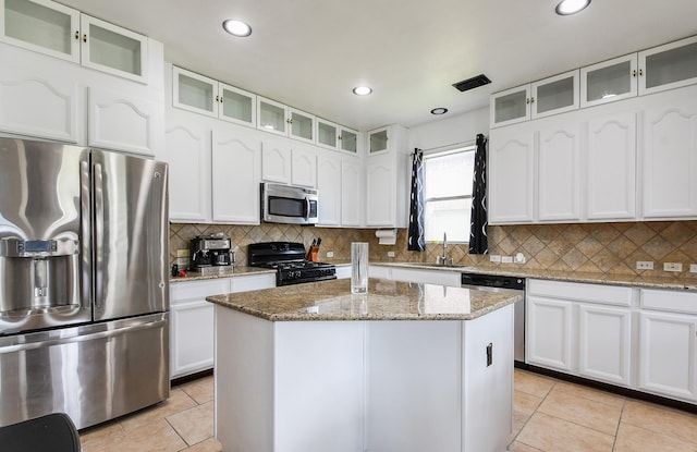 4723 Peninsula Garden Way, Humble, TX 77396 - kitchen with stainless steel appliances, light tile patterned flooring, a center island, white cabinets, and recessed lighting