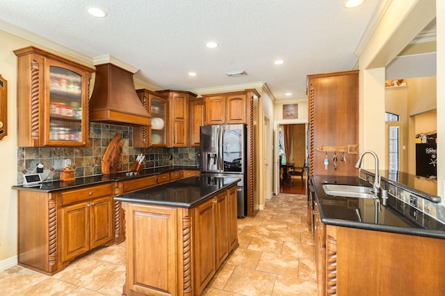 114 Arrowhead Dr, Lake Jackson, TX 77566 - kitchen with custom range hood, stainless steel fridge with ice dispenser, crown molding, backsplash, and recessed lighting