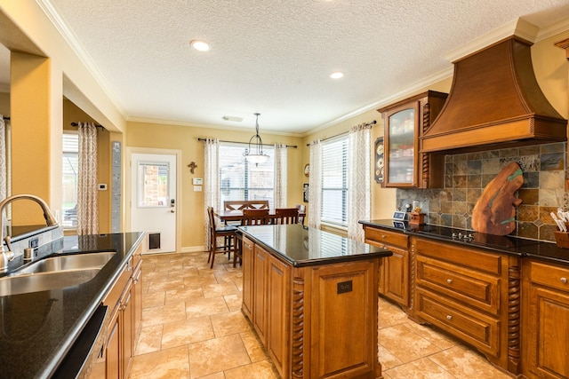 114 Arrowhead Dr, Lake Jackson, TX 77566 - kitchen with custom exhaust hood, black electric cooktop, tasteful backsplash, glass insert cabinets, and a kitchen island