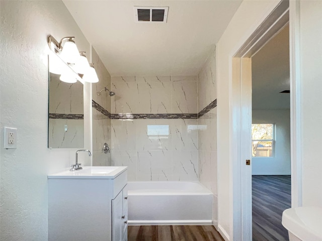 2328 Wimcrest St, Galveston, TX 77551 - bathroom featuring vanity, wood finished floors, shower / bath combination, and a textured wall