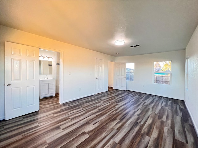 2328 Wimcrest St, Galveston, TX 77551 - unfurnished bedroom featuring dark wood-style flooring and connected bathroom