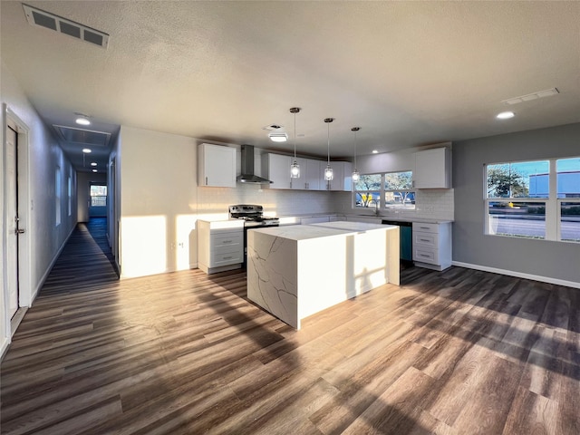 2328 Wimcrest St, Galveston, TX 77551 - kitchen with wall chimney range hood, stainless steel range with electric stovetop, dark wood-type flooring, tasteful backsplash, and light countertops