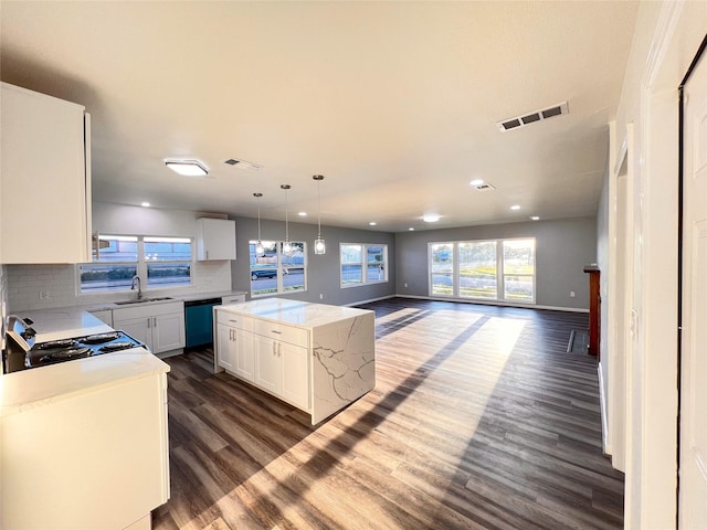 2328 Wimcrest St, Galveston, TX 77551 - kitchen with dishwashing machine, open floor plan, dark wood-style floors, tasteful backsplash, and white cabinetry