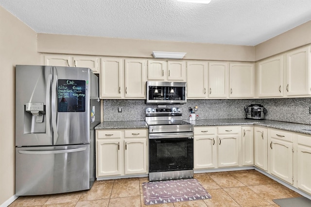 202 Twin Harbors Dr, Onalaska, TX 77360 - kitchen featuring stainless steel appliances, a textured ceiling, decorative backsplash, light tile patterned flooring, and dark stone countertops