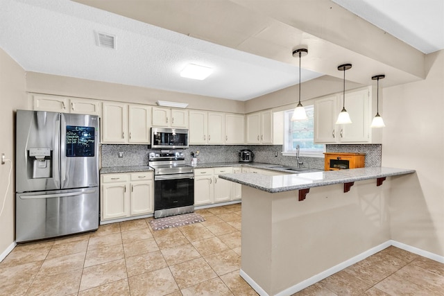 202 Twin Harbors Dr, Onalaska, TX 77360 - kitchen featuring stainless steel appliances, a peninsula, decorative backsplash, and hanging light fixtures