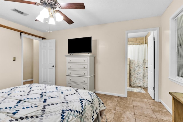202 Twin Harbors Dr, Onalaska, TX 77360 - bedroom with light tile patterned floors, ensuite bath, and a ceiling fan