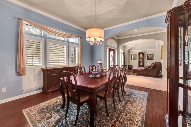 13603 Sand Mountain Ln, Houston, TX 77044 - dining room with arched walkways, ornamental molding, dark wood-style flooring, a chandelier, and recessed lighting