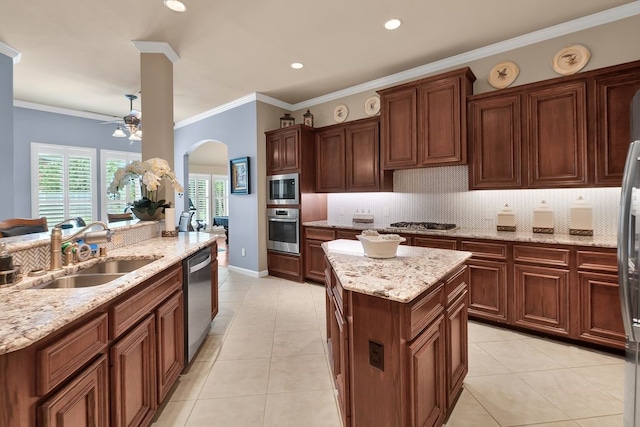 13603 Sand Mountain Ln, Houston, TX 77044 - kitchen featuring appliances with stainless steel finishes, arched walkways, a center island, backsplash, and a ceiling fan