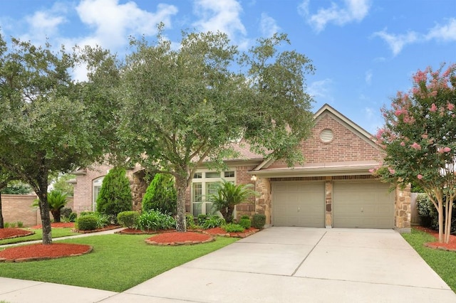 13603 Sand Mountain Ln, Houston, TX 77044 - view of front facade with an attached garage, driveway, a front lawn, brick siding, and stone siding