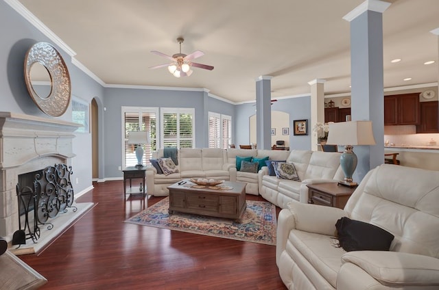 13603 Sand Mountain Ln, Houston, TX 77044 - living area featuring decorative columns, a ceiling fan, crown molding, a fireplace with raised hearth, and dark wood-style floors