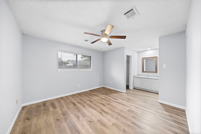 1617 Pecan Hollow St, Pearland, TX 77581 - unfurnished bedroom featuring a textured ceiling, light wood-style flooring, connected bathroom, and ceiling fan