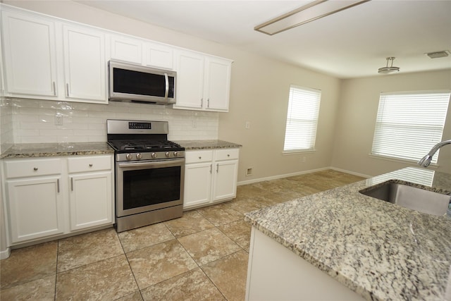 2434 Ranch Hollow Ct, Katy, TX 77494 - kitchen featuring stainless steel appliances, tasteful backsplash, white cabinetry, and light stone counters