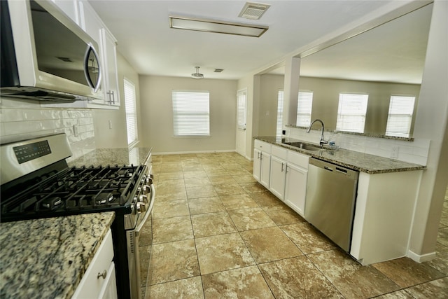 2434 Ranch Hollow Ct, Katy, TX 77494 - kitchen with stainless steel appliances, tasteful backsplash, stone counters, and white cabinets