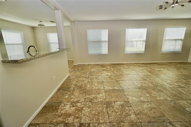 2434 Ranch Hollow Ct, Katy, TX 77494 - empty room featuring healthy amount of natural light and stone finish floors