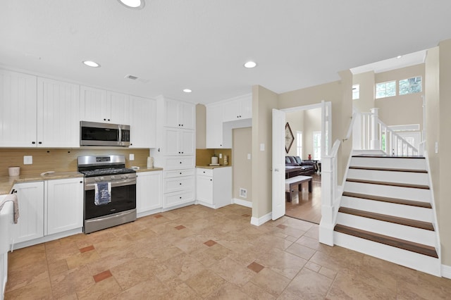 46 Lightwood Trce, The Woodlands, TX 77382 - kitchen with appliances with stainless steel finishes, light countertops, white cabinetry, backsplash, and recessed lighting