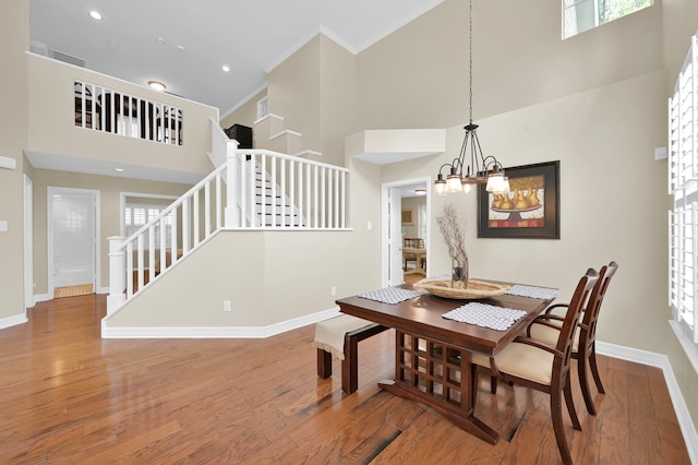 46 Lightwood Trce, The Woodlands, TX 77382 - dining space with a towering ceiling, wood finished floors, stairway, a chandelier, and ornamental molding