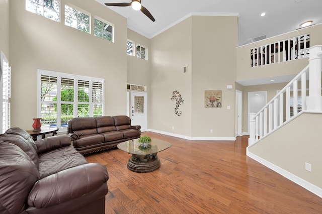 46 Lightwood Trce, The Woodlands, TX 77382 - living room featuring a ceiling fan, stairs, wood finished floors, crown molding, and a towering ceiling