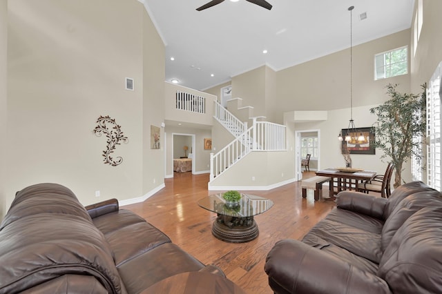 46 Lightwood Trce, The Woodlands, TX 77382 - living room featuring a high ceiling, stairway, ceiling fan, wood finished floors, and a chandelier