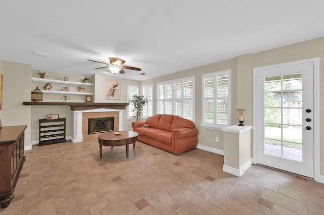 46 Lightwood Trce, The Woodlands, TX 77382 - living room featuring a ceiling fan, light stone finish floors, and a tile fireplace