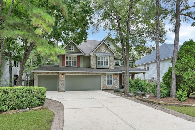 46 Lightwood Trce, The Woodlands, TX 77382 - view of front of home with concrete driveway, an attached garage, and stone siding