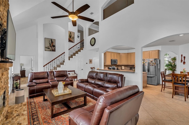 7710 Aerobic Ave, Humble, TX 77346 - living area featuring a towering ceiling, ceiling fan, arched walkways, stairway, and light tile patterned flooring
