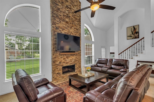 7710 Aerobic Ave, Humble, TX 77346 - living area featuring high vaulted ceiling, healthy amount of natural light, ceiling fan, light tile patterned floors, and stairway