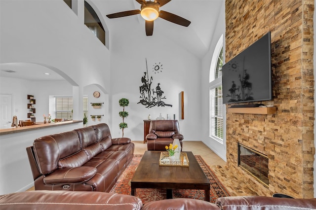 7710 Aerobic Ave, Humble, TX 77346 - living area with high vaulted ceiling, ceiling fan, light tile patterned floors, arched walkways, and a fireplace