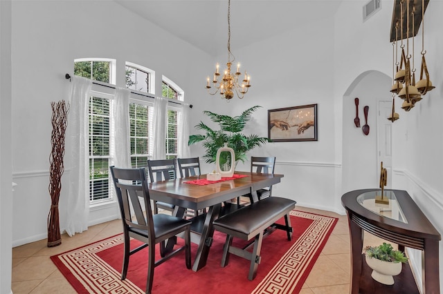 7710 Aerobic Ave, Humble, TX 77346 - dining area with light tile patterned floors, a high ceiling, a chandelier, and arched walkways