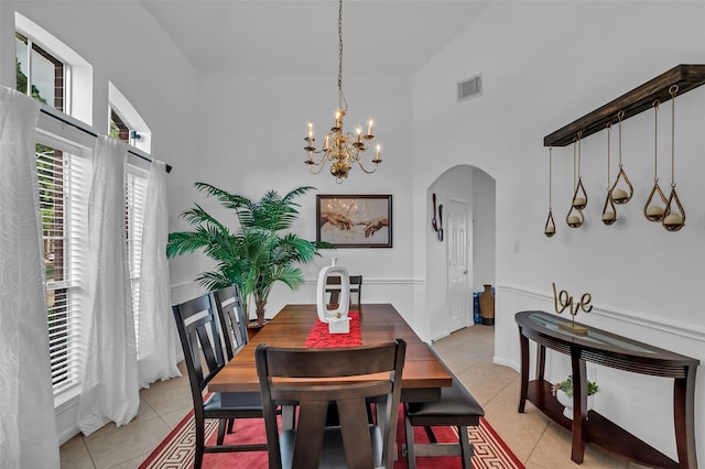 7710 Aerobic Ave, Humble, TX 77346 - dining area featuring high vaulted ceiling, arched walkways, light tile patterned floors, and a chandelier