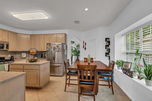7710 Aerobic Ave, Humble, TX 77346 - kitchen with appliances with stainless steel finishes, arched walkways, light countertops, decorative backsplash, and light brown cabinetry