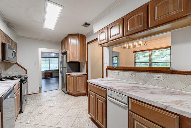 1226 Timbergrove Ln, Houston, TX 77008 - kitchen featuring appliances with stainless steel finishes, decorative backsplash, light tile patterned floors, brown cabinetry, and ornamental molding