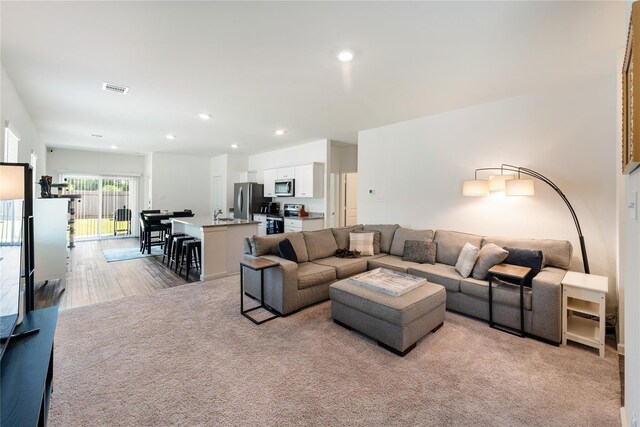 10138 California Lily Ln, Houston, TX 77016 - living area with recessed lighting, light carpet, and light wood-style flooring